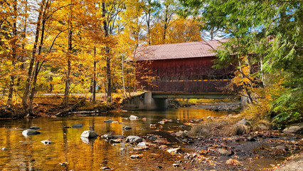 Wall Mural - Red, wooden, covered bridge with beautiful autumn colors and river reflections, Stowe, Vermont, USA