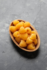 Wall Mural - Organic Yellow Raspberries in wooden bowl. Ripe juicy fresh berry fruit.. Healthy food.