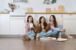 Group of Cheerful Asian women sitting on the floor on a kitchen. Happy Korean friends laugh at funny joke enjoy eating pizza and noodles, take-away food spending time together on weekend at home.