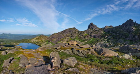 Poster - Russia. South of Siberia. Western Sayan. Panoramic view of a high-altitude lake surrounded by harsh rocks from a mountain pass in the Ergaki Natural Mountain Park.