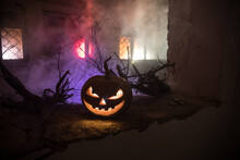 Scary Halloween Pumpkin In The Mystical House Window At Night Or Halloween Pumpkin In Night On Room With Blue Window. Symbol Of Halloween In Window. Selective Focus