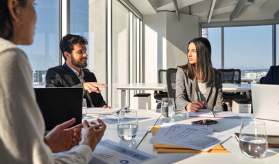 Wall Mural - Busy young professional international board executives, diverse team young people group discussing marketing project strategy working together in meeting room consulting sitting at office table.