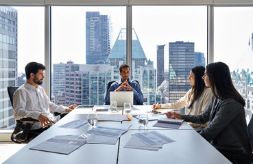 Busy international professional business team young people working together in teamwork at group meeting. Multiethnic diverse executives discussing corporate project in office board room at table.