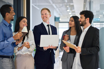 Happy international professional team young business people talking in office hallway. 5 smiling diverse multiethnic employees group, multicultural coworkers company staff having fun chatting at work.