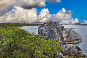 Coastal scenery with huge granitic rocks, eucalyptus forest and a cloudy sky in Two Peoples Bay Nature Reserve, close to Albany, Western Australia.
