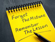 Leinwandbild Motiv Notebook with motivation quote forget the mistake remember the lesson.