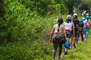 group of hikers with harness and helmet surrounded by vegetation and green nature in costa rica