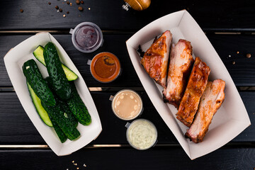 Poster - Pork fillet steak with salted cucumbers and sauces in a paper box.