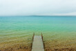 Wooden dock on crystal clear blue Torch Lake in Northern Michigan.
