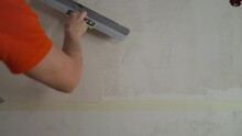 Plasterer Applies Plaster On The Wall During Repair And Restoration Work. Leveling The Wall With A Spatula. Puttying The Wall, Leveling With A Spatula. The Builder Levels The Putty On The Wall With A 