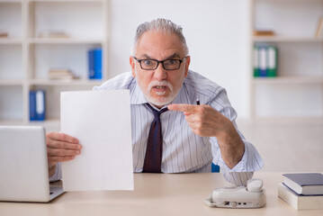 Wall Mural - Old male employee working in the office