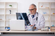 © Elnur - Old male doctor radiologist working in the clinic