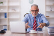 © Elnur - Old male employee drinking coffee during break