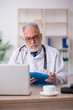 © Elnur - Old male doctor sitting in the clinic