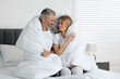 © New Africa - Lovely mature couple wrapped in blanket on bed at home