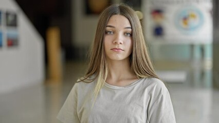 Canvas Print - Young beautiful girl sitting on table with serious face at library