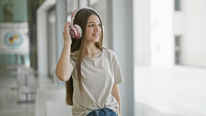 Poster - Young beautiful girl listening to music and dancing at library