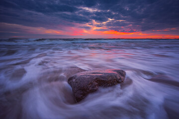 Baltic seashore with beautiful rock and sunset light.