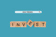 © Sumeth - Placed a wooden block with the text 'TRENDS' 2024 investment trends, business search and marketing planning on a blue background.