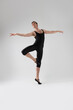 © danmorgan12 - Male Ballet Dancer Flexible Athletic Man Posing in Black Tights in Ballanced Dance Pose With Hands Lifted and Leg Crossed.