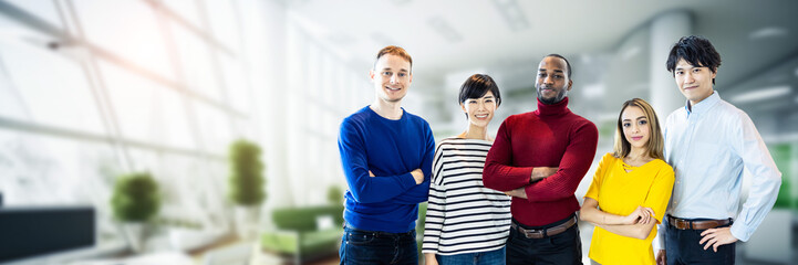 Poster - Group of multinational people standing in modern office. Wide angle visual for banners or advertisements.