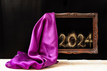silky fabric unveiling an levitating wooden frame, with 2024 new year  number written with sparker firework