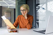 © Liubomir - Bad news layoff notice, business woman upset holding mail envelope, female worker reading news at workplace inside office, working with laptop sitting and finance papers.