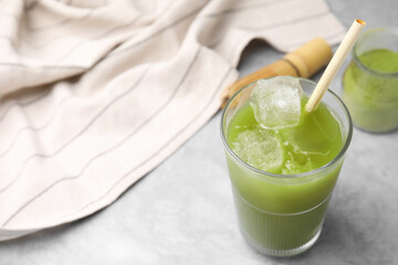 Glass of delicious iced green matcha tea on light grey table, above view. Space for text