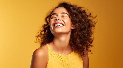 Canvas Print - Young woman laughs against a yellow background.