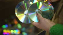 Close-up High Angle View Female Hands Throwing Compact Discs In Box Indoors In Slow Motion. Closeup Unrecognizable Young Caucasian Woman Sorting Used Trash On Factory For Recycling