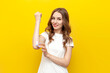 young cute girl applies skin cream on the elbow of her hand on yellow isolated background, woman takes care of her skin