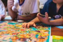 Process Of Playing Board Game And Having Fun With Friends And Family Indoors, Board Game Concept, Group Of Kids Children Play Board Games At The Table, Roll The Dice