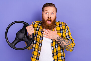 Wall Mural - Photo of impressed person hand touch chest open mouth hold steering wheel isolated on violet color background