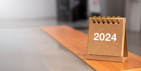 Poster - happy new year 2024 banner background. 2024 numbers year on brown spiral desk calendar cover standin
