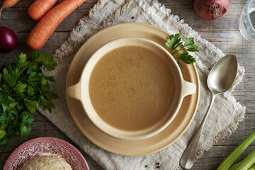 Wall Mural - A soup plate of chicken bone broth on a table