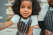 © chokniti - Kind African american parents teaching their adorable daughter how to cook healthy food, free space of kitchen, Happy black people family preparing healthy food in kitchen together