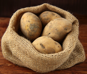 Sticker - organic raw potatoes in a bag on the table