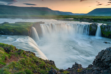 Wall Mural - Sunset over Godafoss waterfall flowing in summer at Iceland