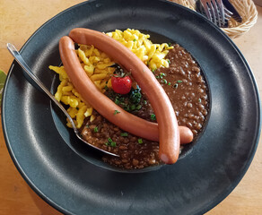 Pasta with beans served with two sausages