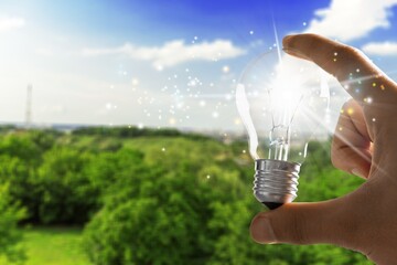 Wall Mural - hand holding classic light bulb for renewable energy.