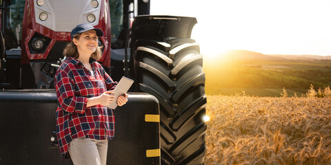 Aufkleber - Woman farmer with a digital tablet on the background of an agricultural tractor