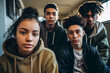 Group of four teenagers, one girl and three boys, in a serious attitude in high school