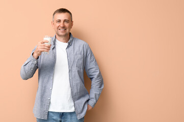 Sticker - Mature man with glass of milk on beige background