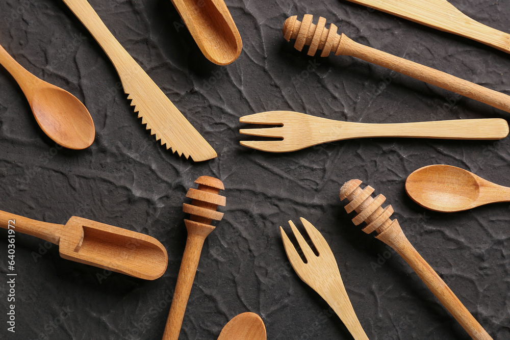 Different wooden kitchen utensils on black background