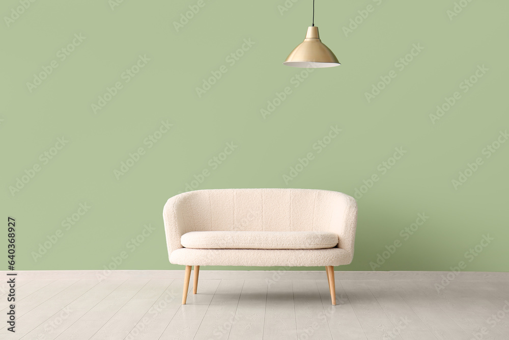 White sofa and lamp near green wall