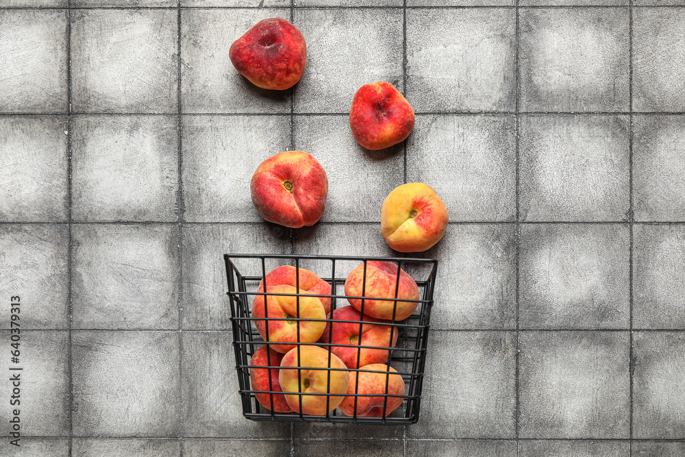 Basket with sweet fig peaches on grey tile background