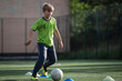 Young boy trains football at the pitch.