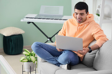 Poster - Young man with laptop video chatting at home