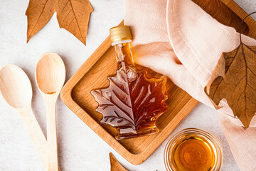 Wall Mural - Bottle of tasty maple syrup on light background