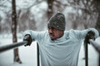 © Marko Geber - Young athletic and fit african man exercising and working out in a outdoors park during winter and snow